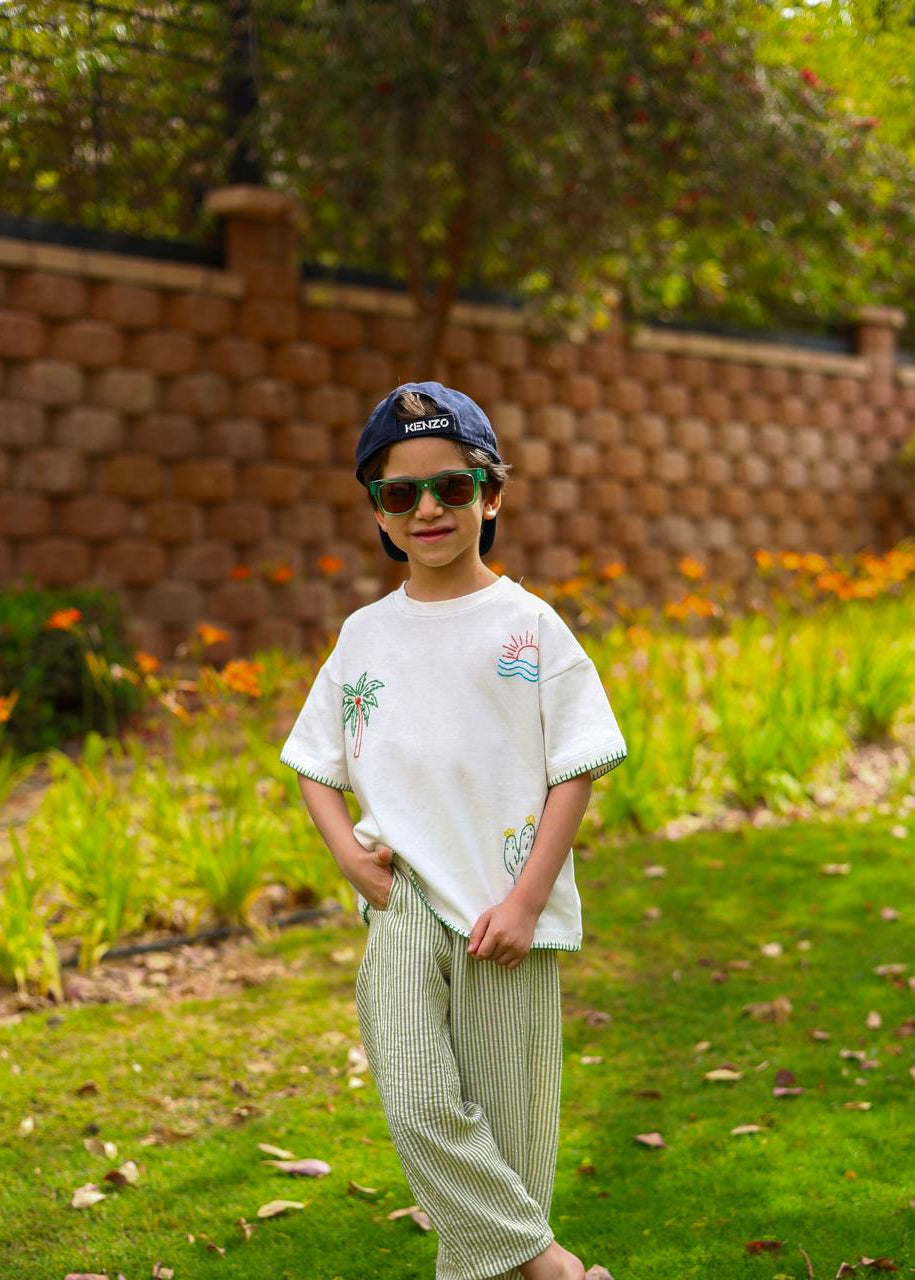 Child wearing sunglasses and a cap in a garden setting