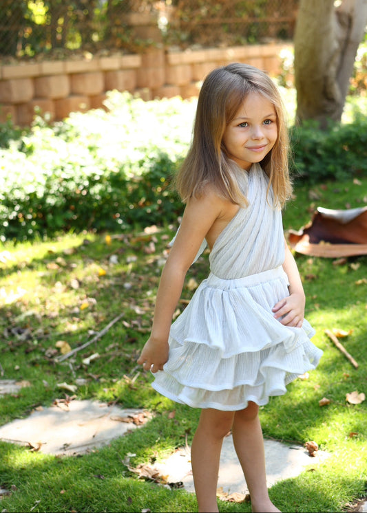 Young girl in a white dress standing in a garden