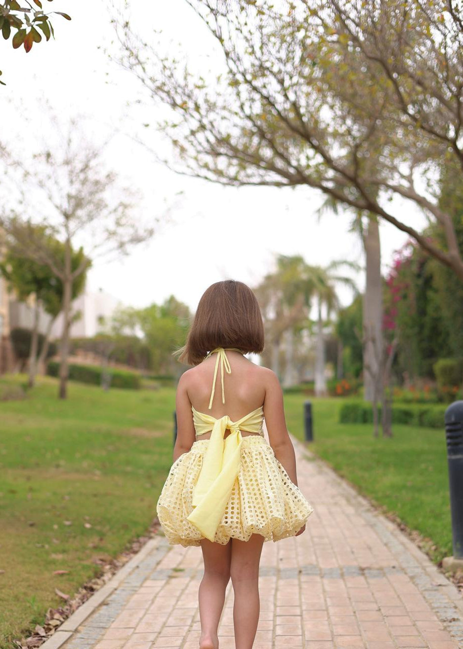 Woman in a yellow dress walking on a path in a park