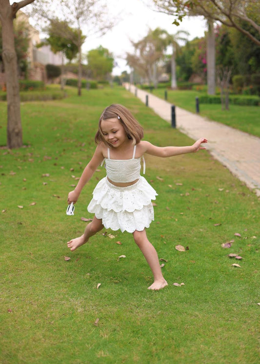 Young girl in a white dress playing in a park