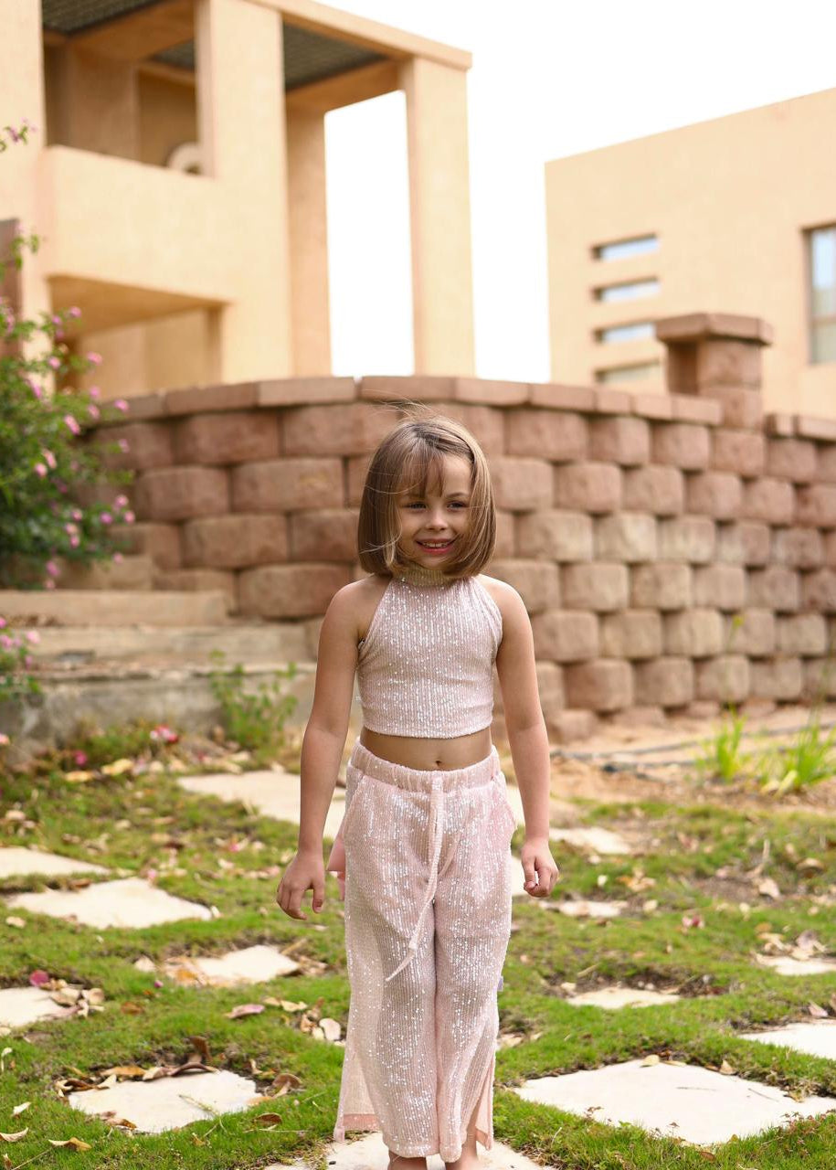 Young girl in a white outfit standing on a grassy area with a building in the background